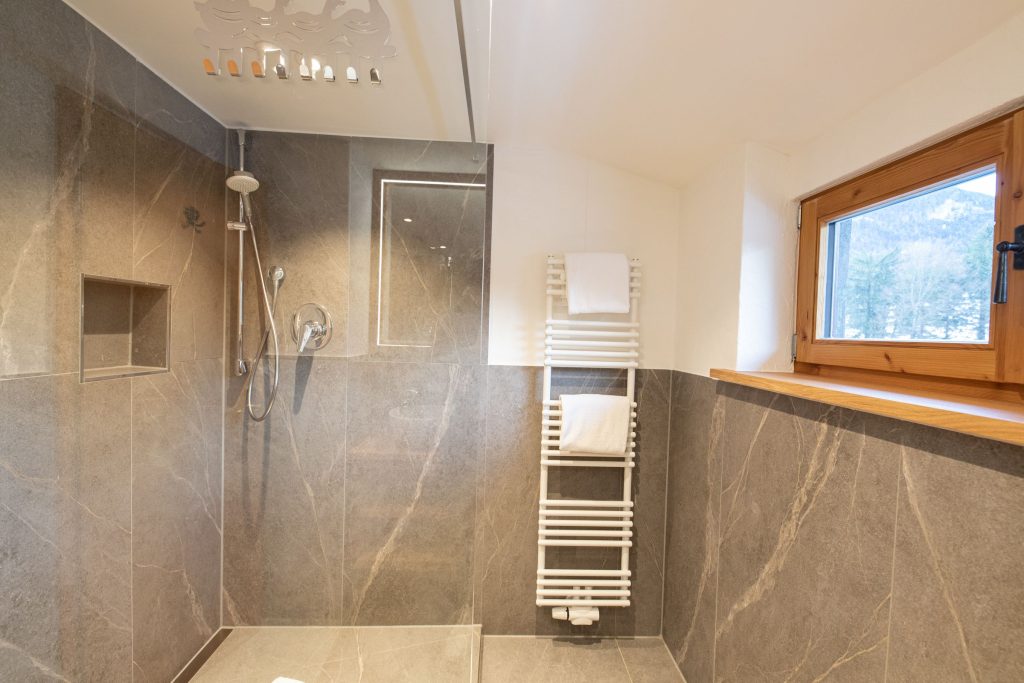 Badezimmer mit Dusche und Fenster in Ferienwohnung in Garmisch-Partenkirchen