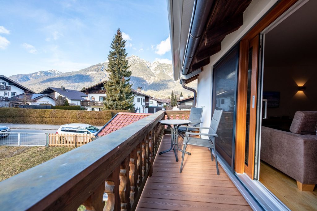 Balkon mit Sitzmöglichkeiten und Tisch in Ferienwohnung in Garmisch-Partenkirchen