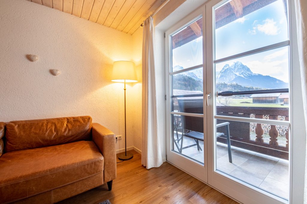 Braunes Sofa mit Fenster in Ferienwohnung in Garmisch-Partenkirchen