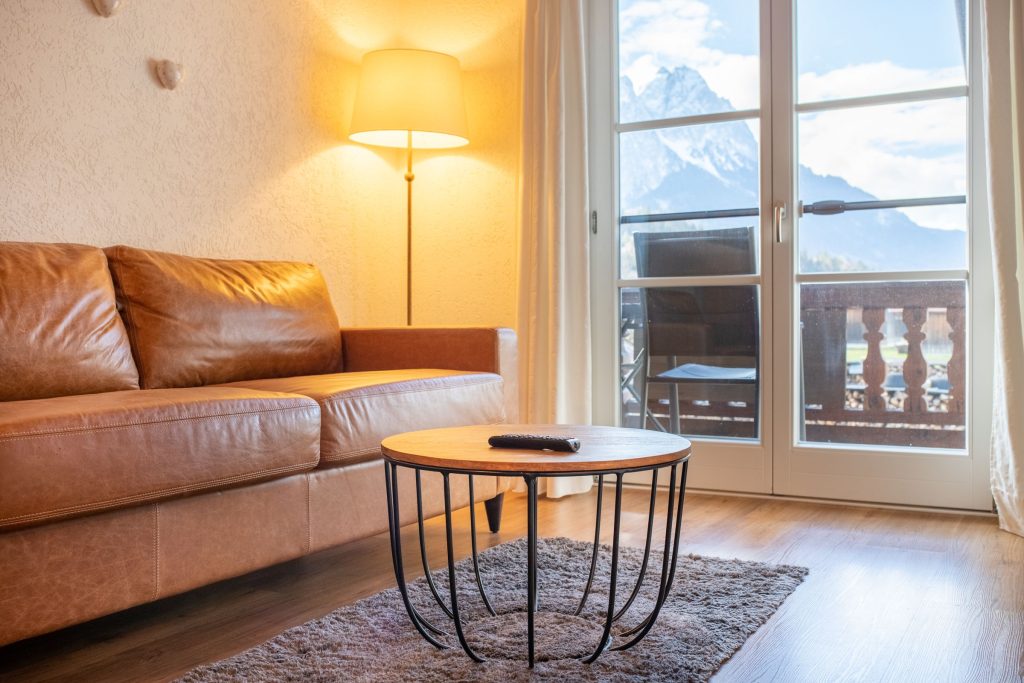 braunes Sofa mit Stehlampe in Ferienwohnung in Garmisch-Partenkirchen