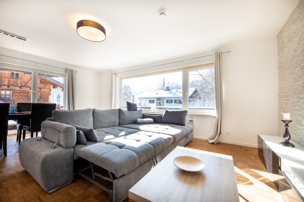 Wohnzimmer mit Couchtisch und grauem Sofa in Ferienwohnung in Garmisch-Partenkirchen