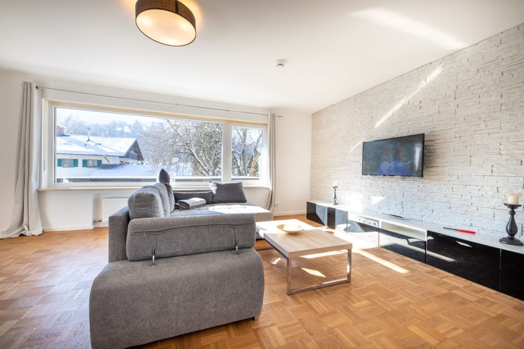 Sofa mit Fernseher und Tisch in Ferienwohnung in Garmisch-Partenkirchen