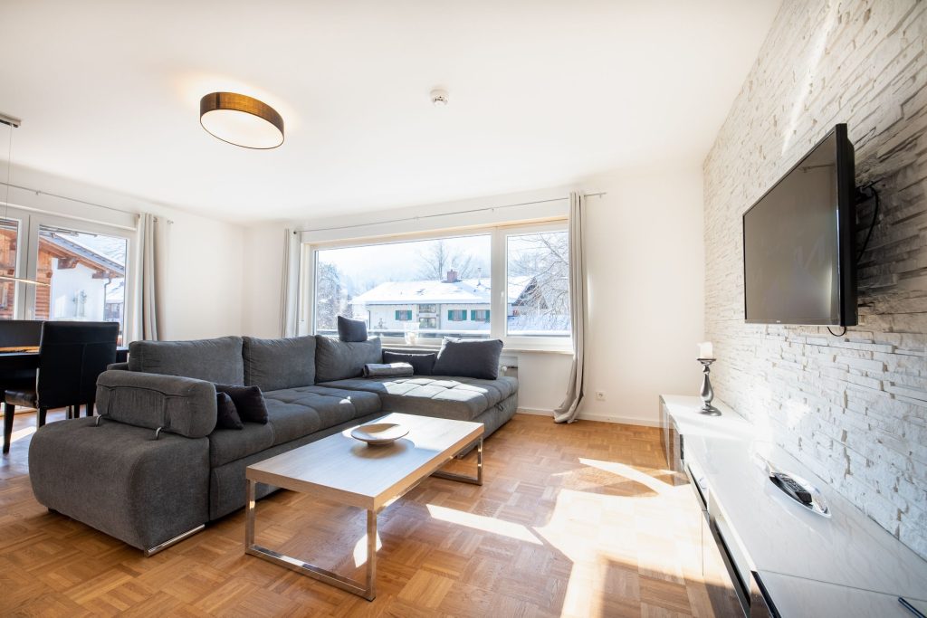 Wohnzimmer mit Fernseher und schwarz weißem Sideboard in Ferienwohnung in Garmisch-Partenkirchen