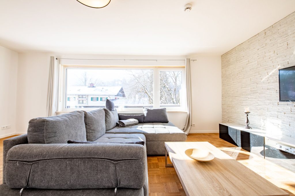 Wohnzimmer mit schwarzem Sideboard und Fernseher in Ferienwohnung in Garmisch-Partenkirchen