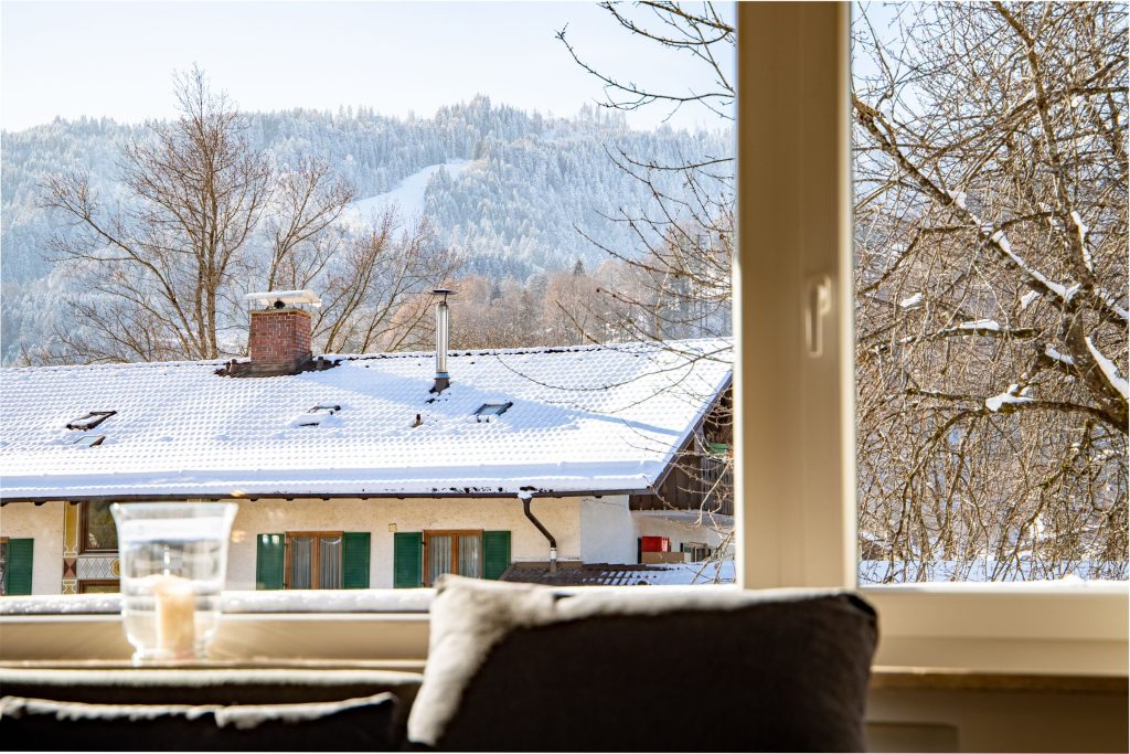 Blick auf die Berge aus dem Wohnzimmer Fenster in Ferienwohnung in Garmisch-Partenkirchen