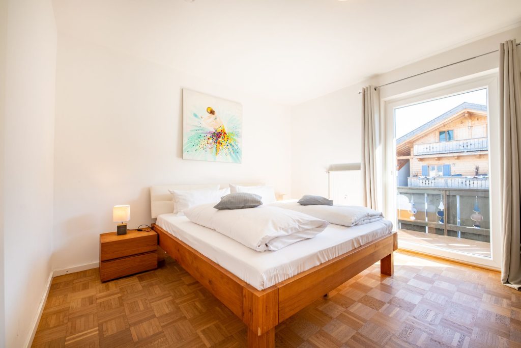 Doppelbett mit Bild und gutem Ausblick in Ferienwohnung in Garmisch-Partenkirchen