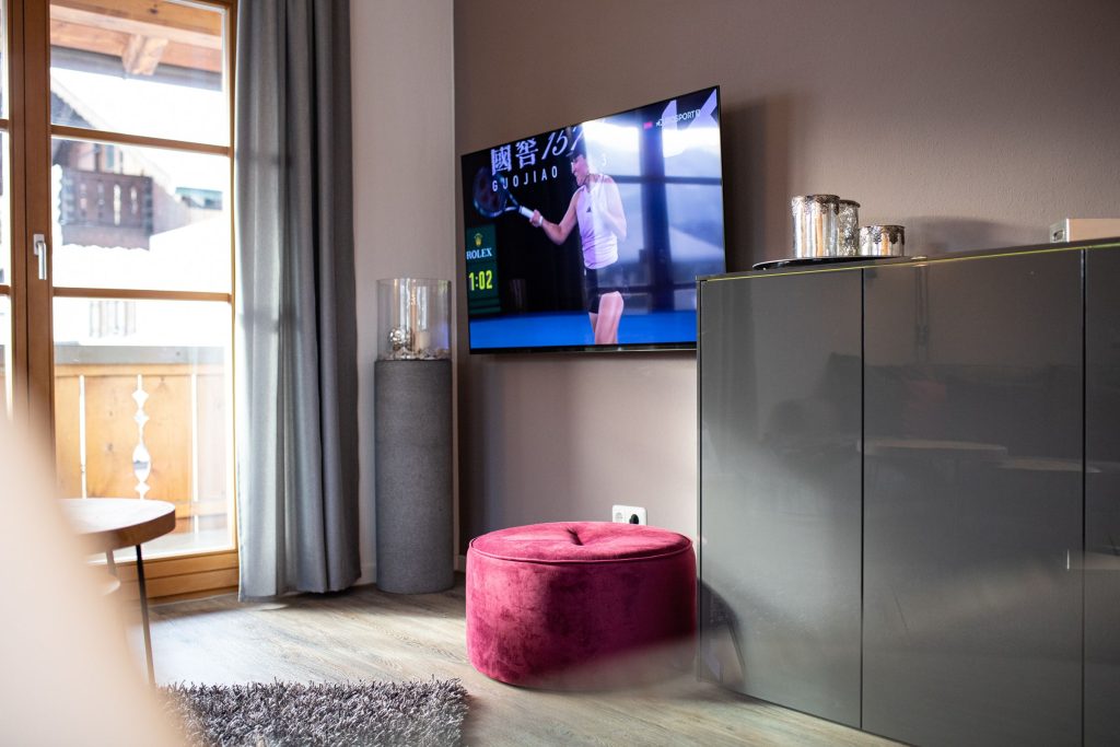 Wohnzimmer mit dunkler Wand und Fernseher in Ferienwohnung in Garmisch-Partenkirchen