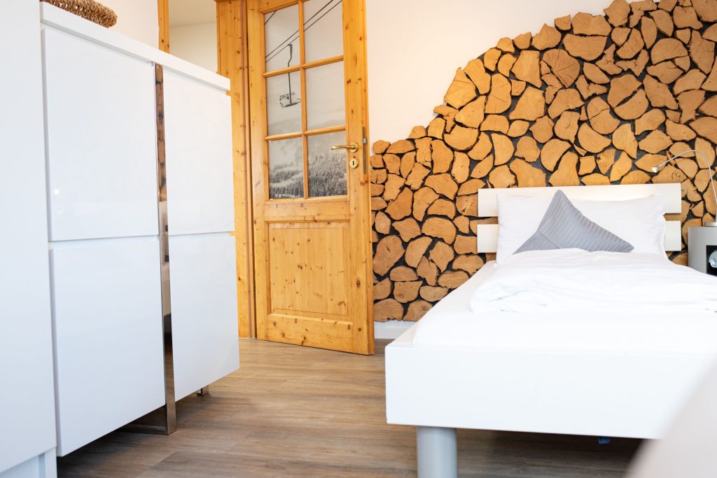 Einzelbett mit einer Holz gemusterten Wand in Ferienwohnung in Garmisch-Partenkirchen