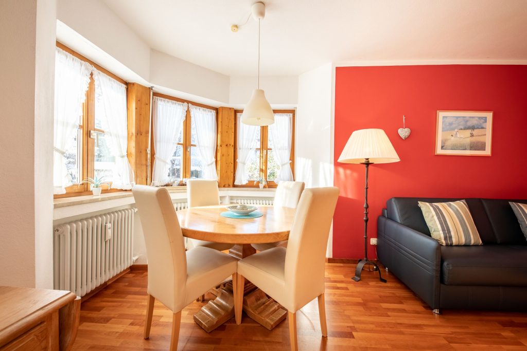 Esstisch mit Stühlen und roter Wand in Ferienwohnung in Garmisch-Partenkirchen