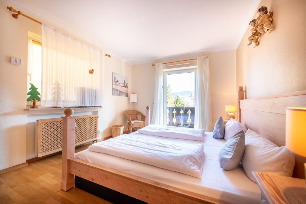 Doppelbett mit Gardienen in Ferienwohnung in Garmisch-Partenkirchen