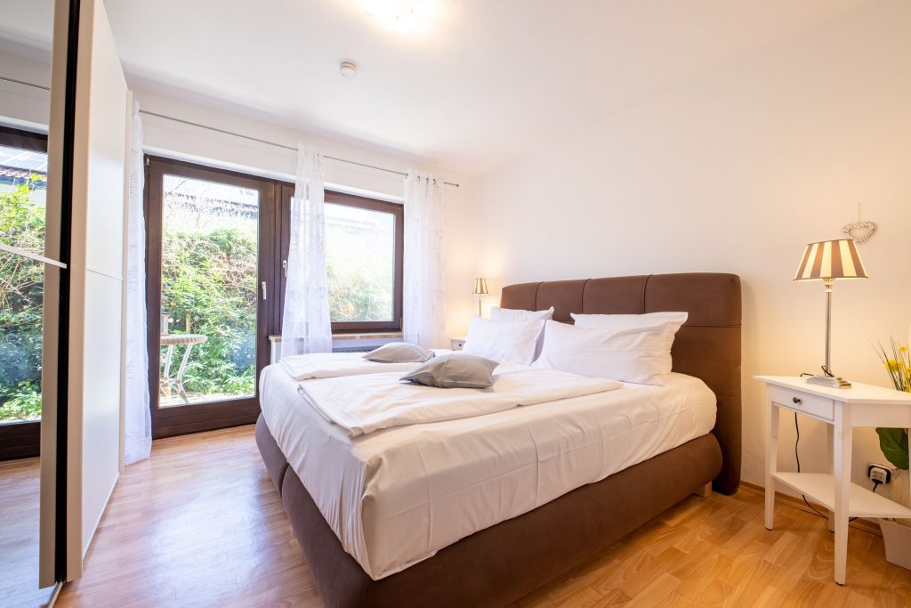 Doppelbett mit Nachttisch in Ferienwohnung in Garmisch-Partenkirchen