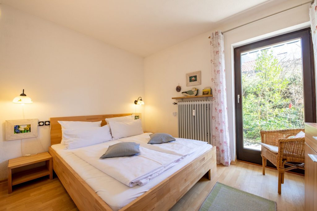 Doppelbett mit Sessel in Ferienwohnung in Garmisch-Partenkirchen