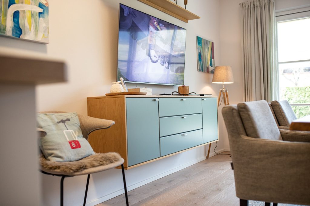 Sideboard und Fernseher mit Stuhl in Ferienwohnung in Garmisch-Partenkirchen