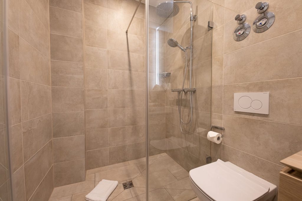 Beige-braunes Badezimmer mit großer Regenfalldusche