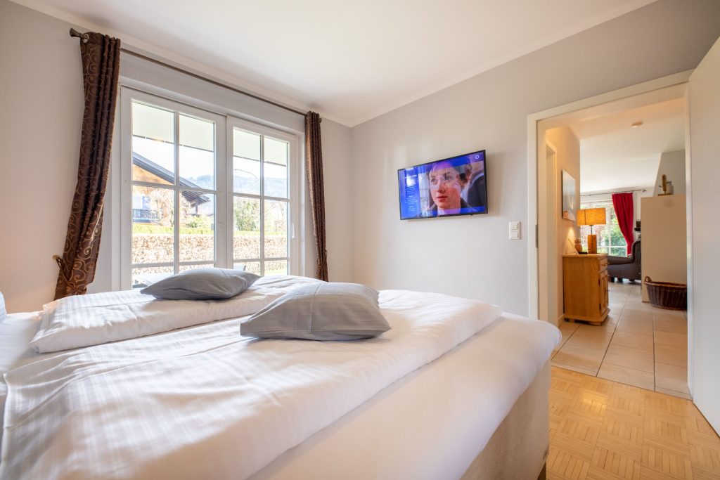 Doppelbett mit Fernseher in Ferienwohnung in Garmisch-Partenkirchen