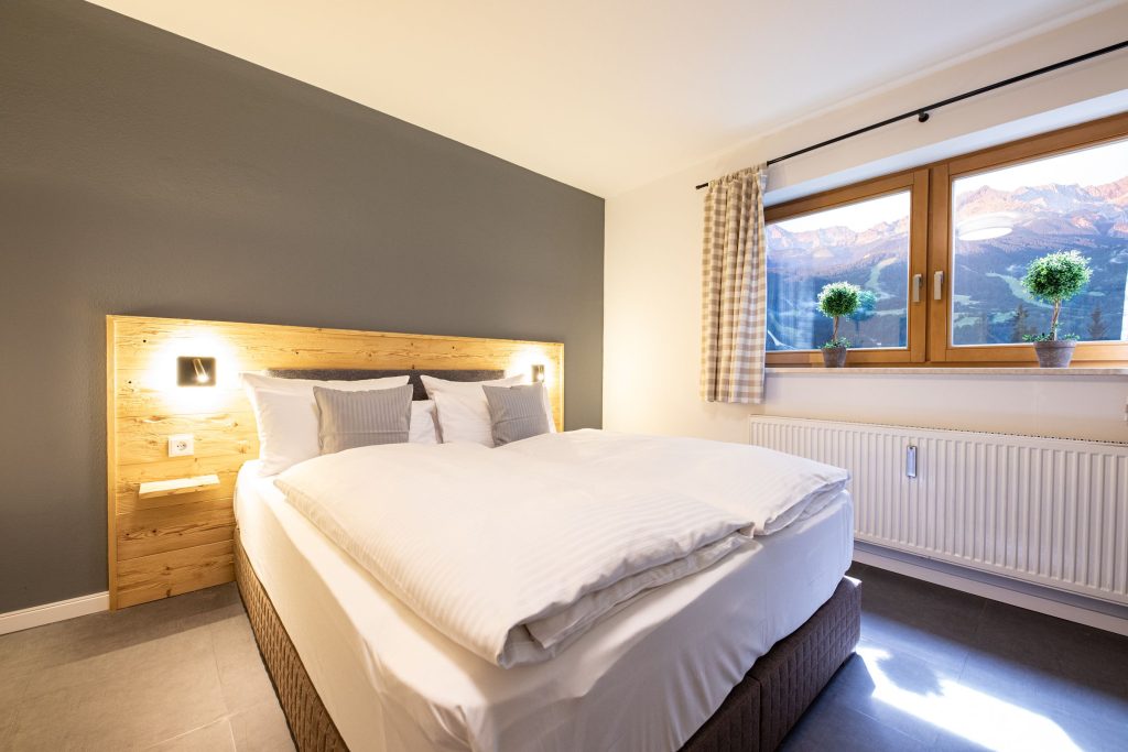 Doppelbett im Schlafzimmer mit schönem Ausblick in Ferienwohnung in Garmisch-Partenkirchen