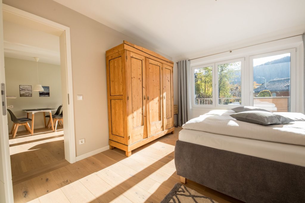 Schlafzimmer mit Blick zum Balkon und Esstisch in Ferienwohnung in Garmisch-Partenkirchen