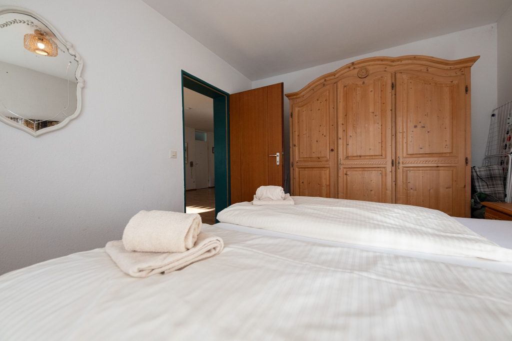 Doppelbett mit Holzschrank in Ferienwohnung in Garmisch-Partenkirchen