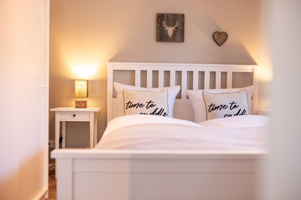 Doppelbett mit kleinen Nachttischlampen in Ferienwohnung in Garmisch-Partenkirchen 