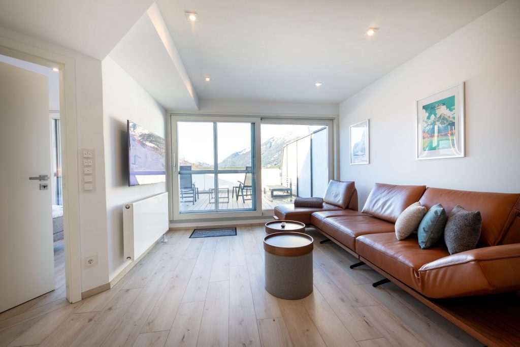 Ledersofa und Blick auf den Balkon in Ferienwohnung in Garmisch-Partenkirchen