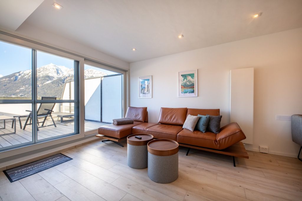 Braunes Ledersofa und Blick auf die Berge in Ferienwohnung in Garmisch-Partenkirchen