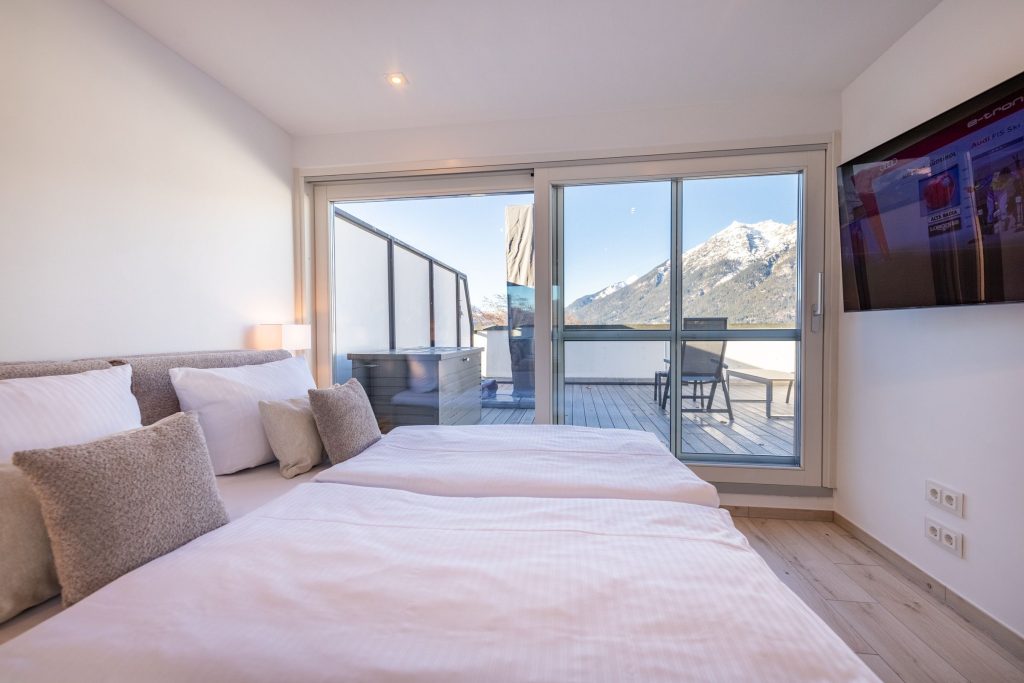 Doppelbett mit pinker Decke in Ferienwohnung in Garmisch-Partenkirchen