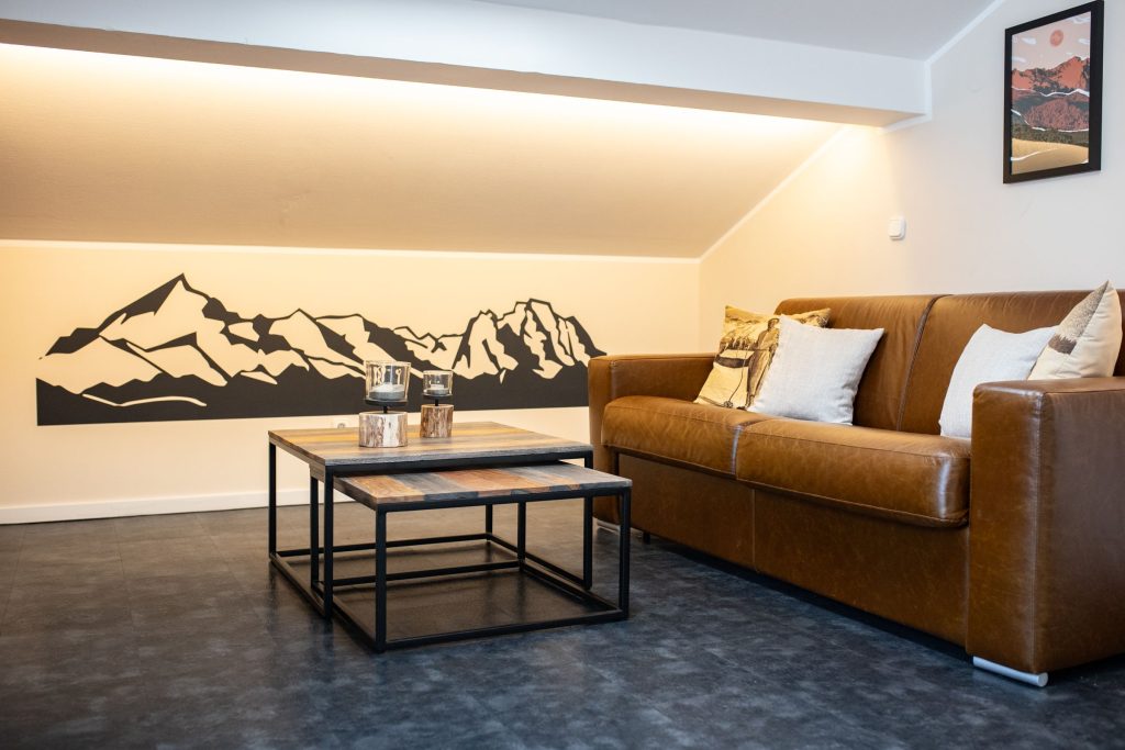 Wohnzimmer mit braunem Sofa in Ferienwohnung in Garmisch-Partenkirchen