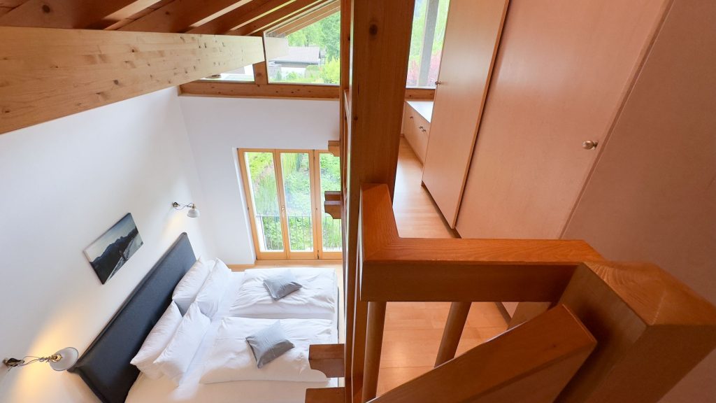 Doppelbett mit Treppe zum Schrank in Ferienwohnung in Garmisch-Partenkirchen