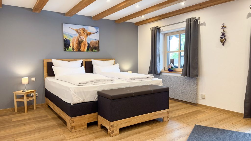 Boxspringbett mit Kuhbild in Ferienwohnung in Garmisch-Partenkirchen