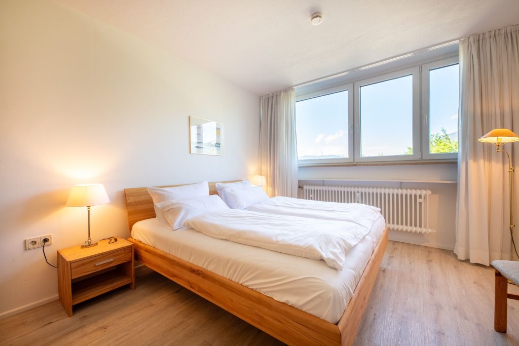 Schlafzimmer mit Holzbett in Ferienwohnung in Garmisch-Partenkirchen