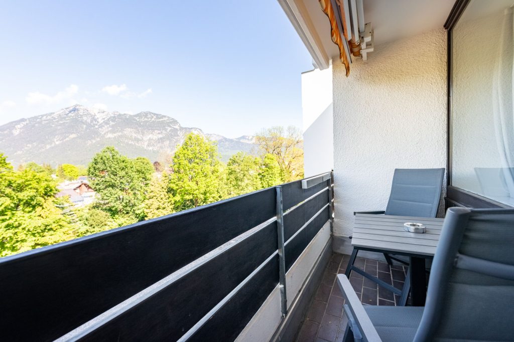 Schmaler Balkon mit Tisch und Stühlen in Ferienwohnung in Garmisch-Partenkirchen