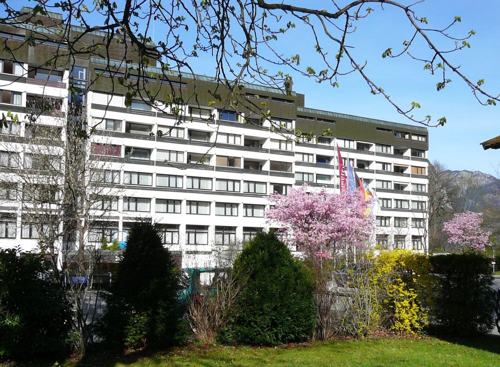 Großes Gebäude hinter Garten in Ferienwohnung in Garmisch-Partenkirchen