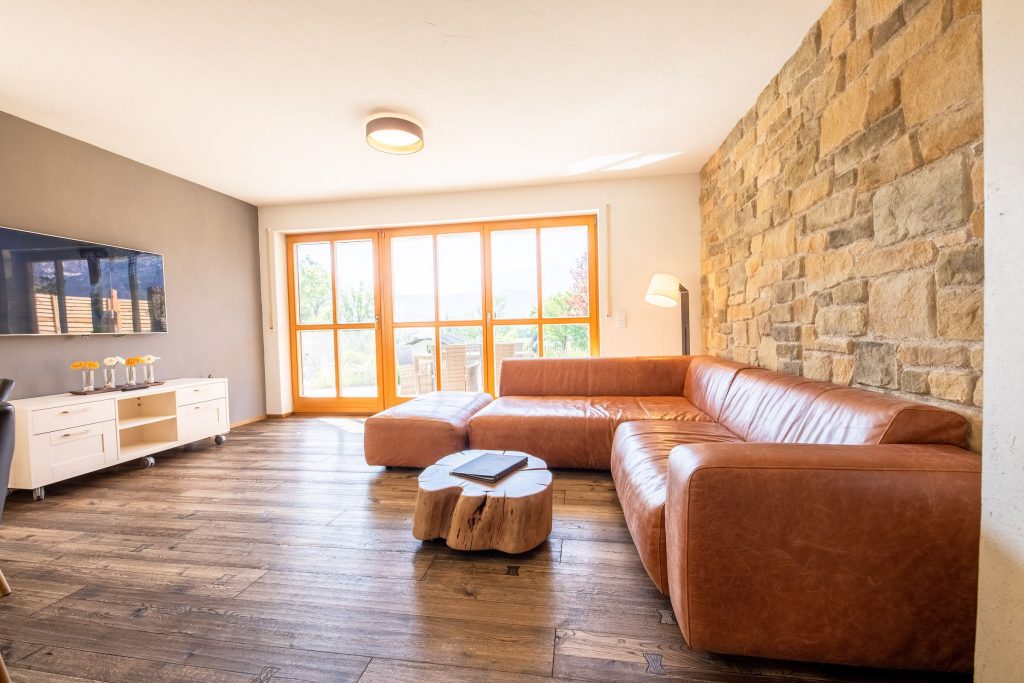 Wohnzimmer mit braunem Sofa und einem Fernseher in Ferienwohnung in Garmisch-Partenkirchen