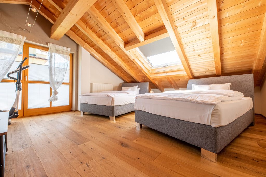 Schlafzimmer mit Sportgerät und zwei Betten in Ferienwohnung in Garmisch-Partenkirchen