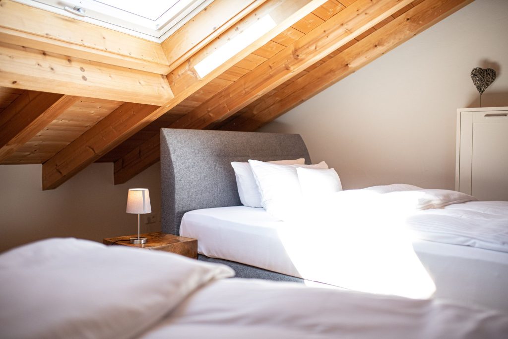 Schlafzimmer mit zwei Betten und einem Dachfenster in Ferienwohnung in Garmisch-Partenkirchen