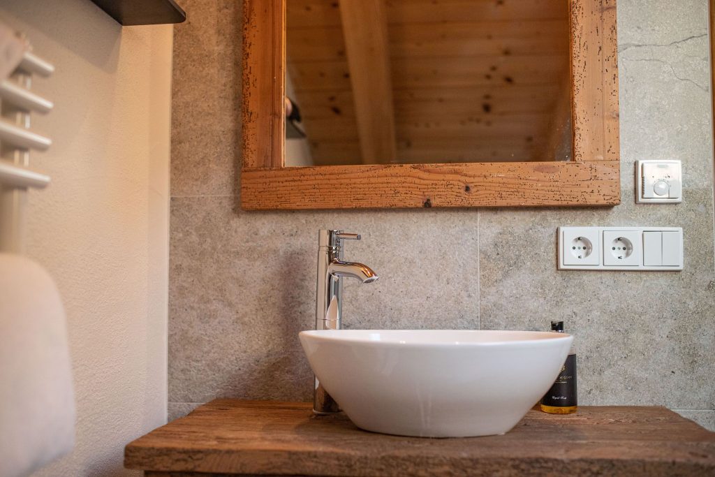 Waschbecken auf einem Holz-Optik Schrank mit Spiegel in Ferienwohnung in Garmisch-Partenkirchen