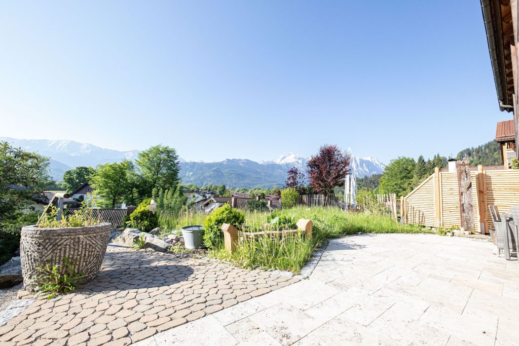 Außenbereich mit Rasenfläche und Terrasse in Ferienwohnung in Garmisch-Partenkirchen