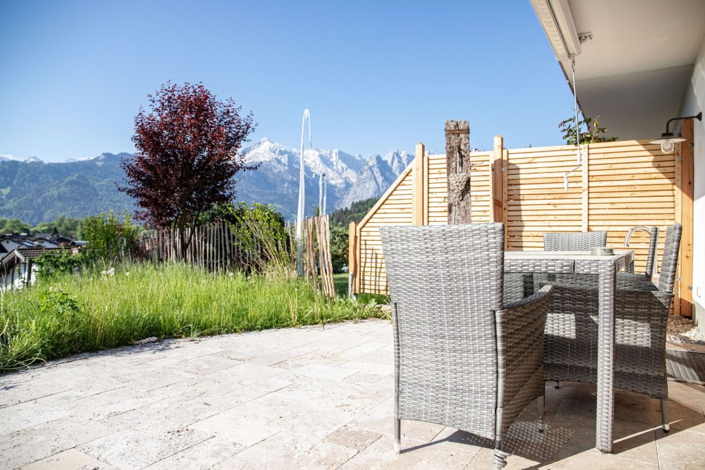 Terrasse mit Stühlen und einem Tisch in Ferienwohnung in Garmisch-Partenkirchen