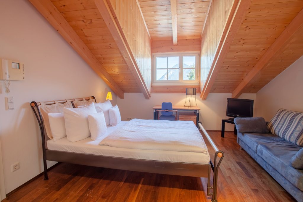 Doppelbett und Dachfenster in Ferienwohnung in Garmisch-Partenkirchen