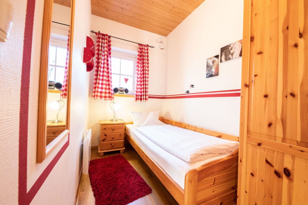 Einzelbett mit Teppich in Ferienwohnung in Garmisch-Partenkirchen