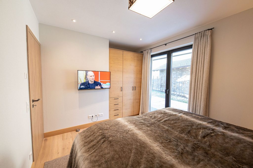 Doppelbett mit Fernseher in Ferienwohnung in Garmisch-Partenkirchen