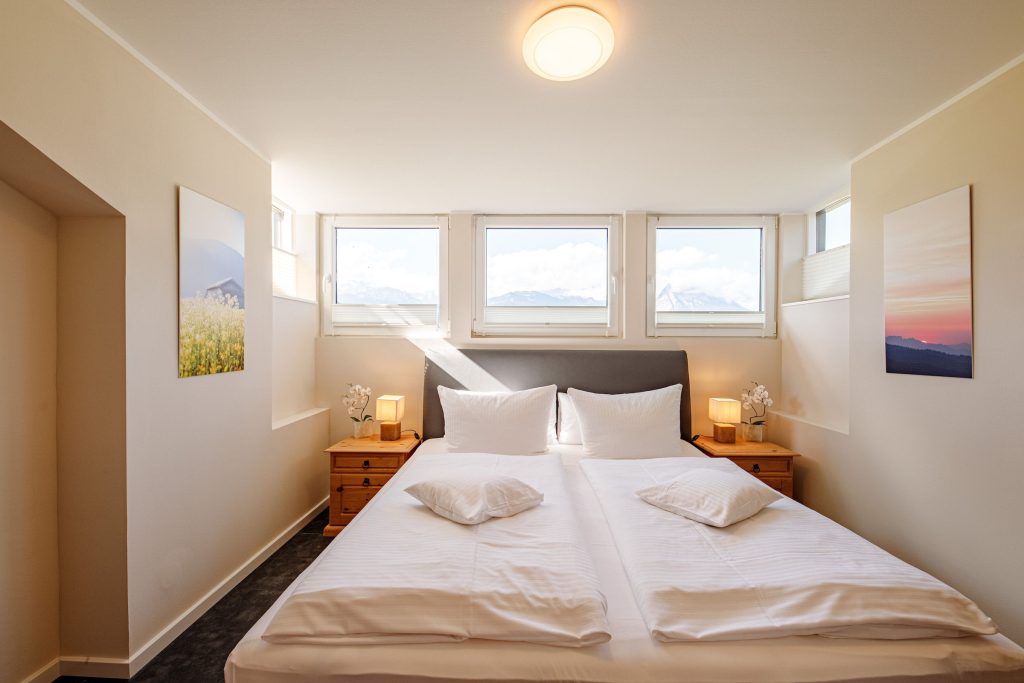 Doppelbett mit Nachttisch in Ferienwohnung in Garmisch-Partenkirchen