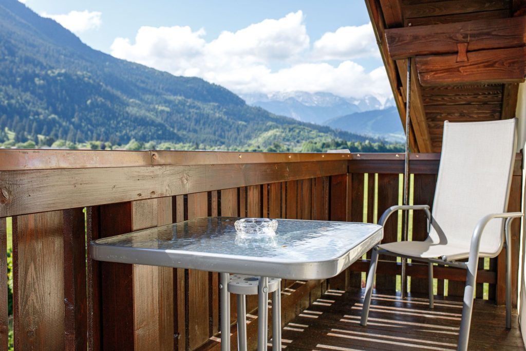 Balkon mit Stuhl und Tisch in Ferienwohnung in Garmisch-Partenkirchen