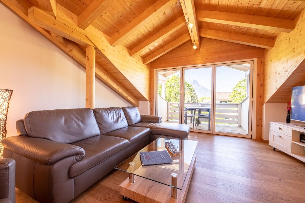 Sofa und Balkon und Fernseher in Ferienwohnung in Garmisch-Partenkirchen