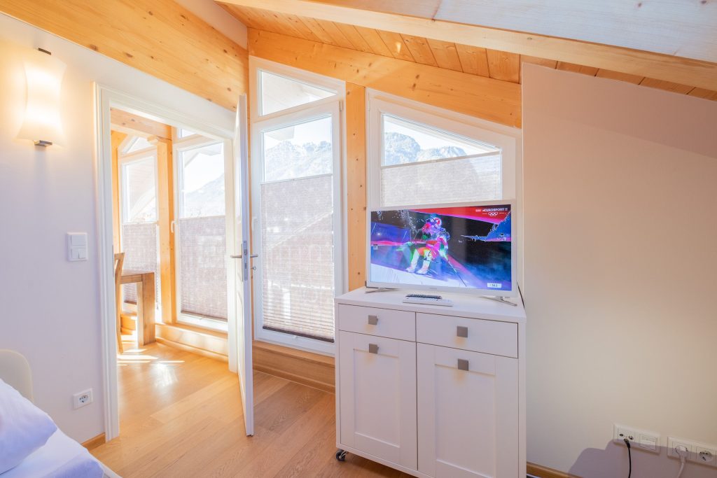 Bett mit Fernseher in Ferienwohnung in Garmisch-Partenkirchen