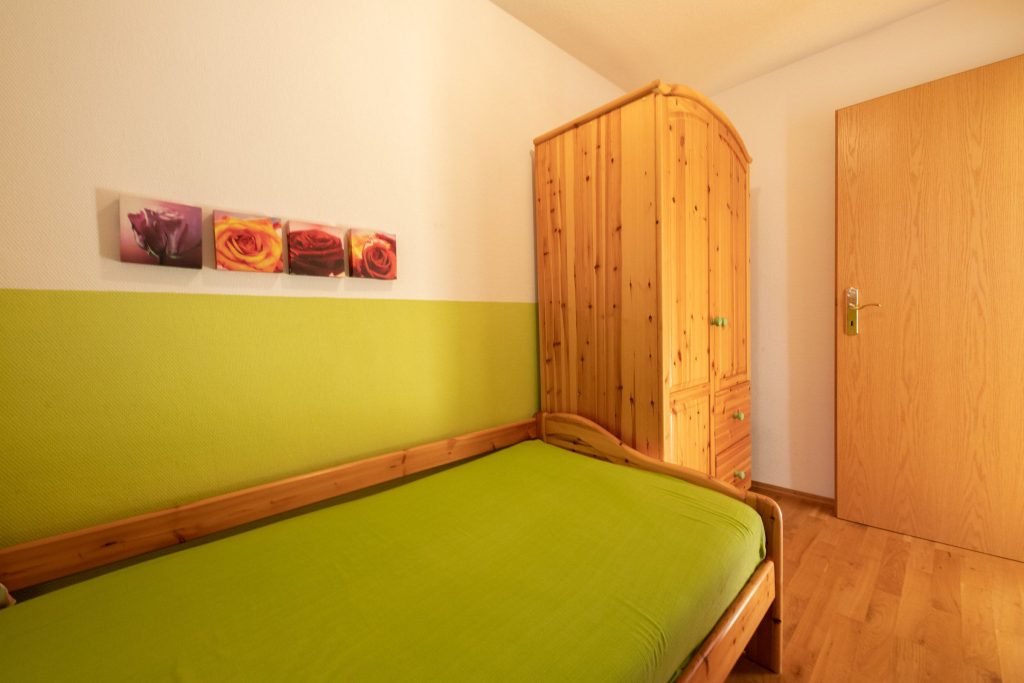 Einzelbett und Schrank in Ferienwohnung in Garmisch-Partenkirchen