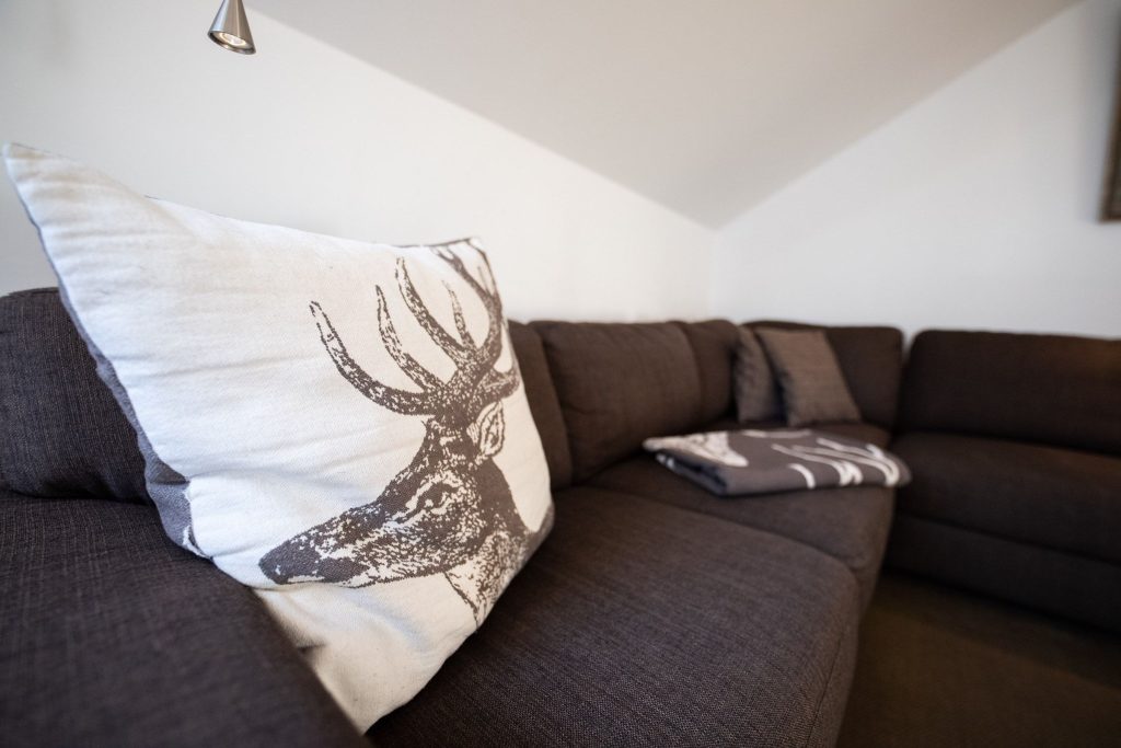 Sofa mit Kissen und Tagesdecke in Ferienwohnung in Garmisch-Partenkirchen