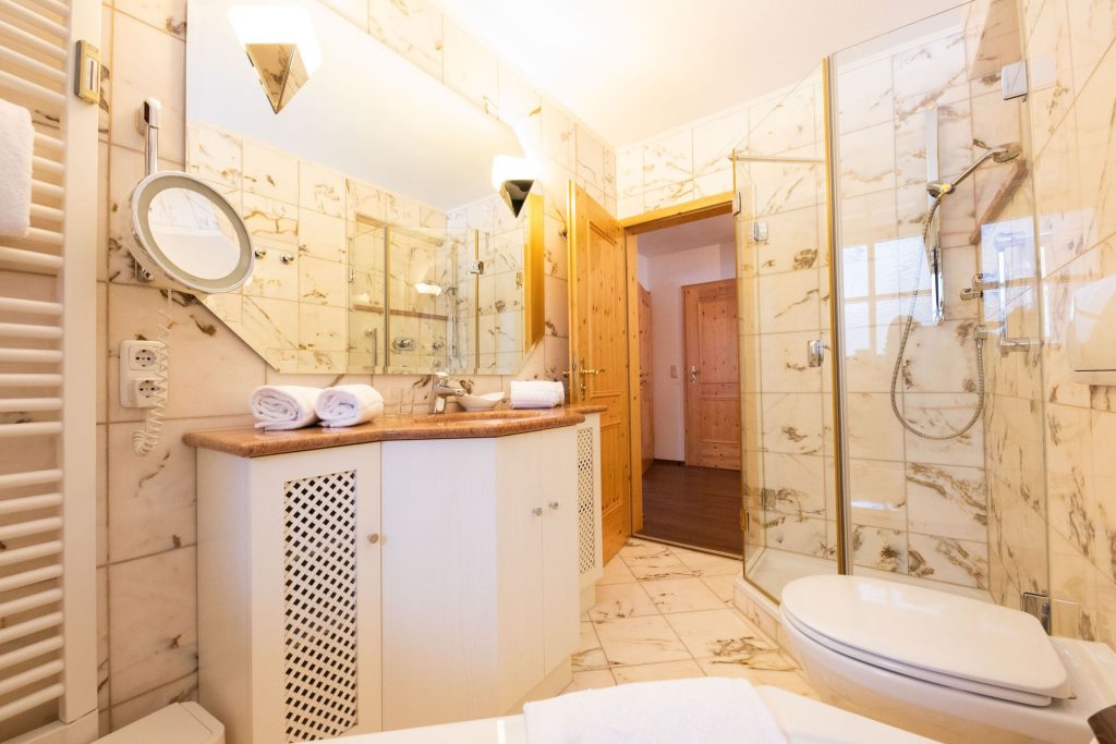 Badezimmer mit großem Spiegel und Dusche in Ferienwohnung in Garmisch-Partenkirchen