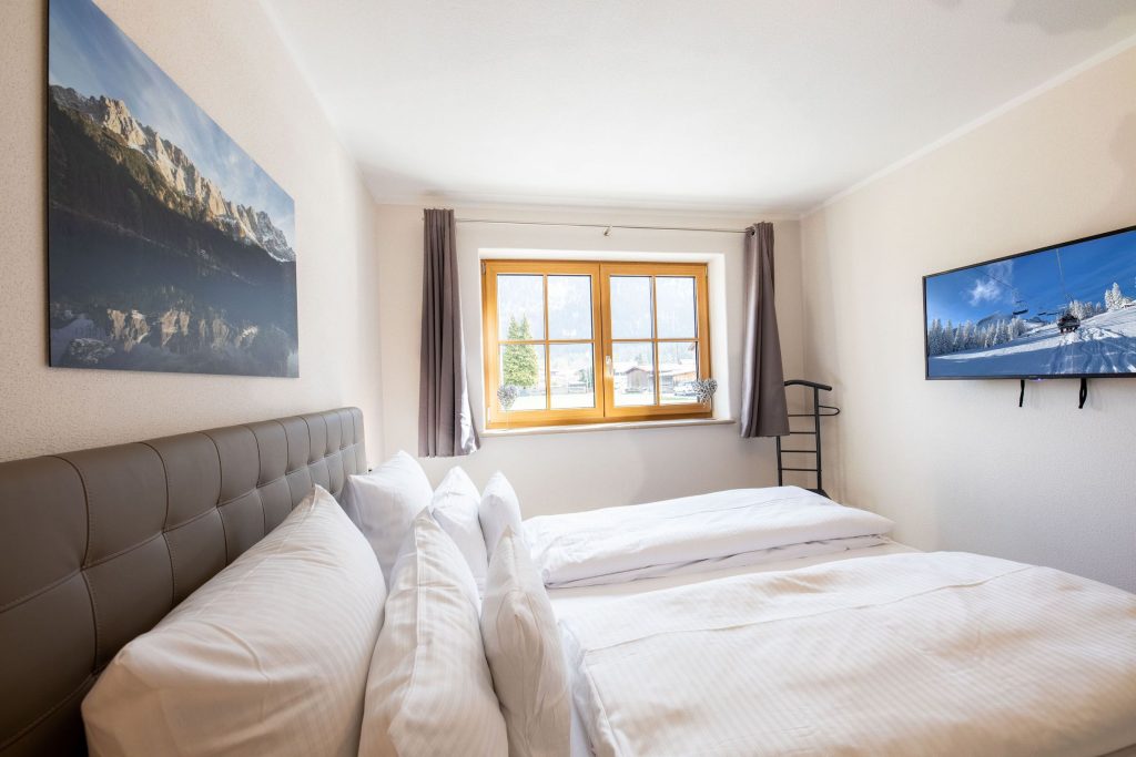 Doppelbett mit Fernseher in Ferienwohnung in Garmisch-Partenkirchen