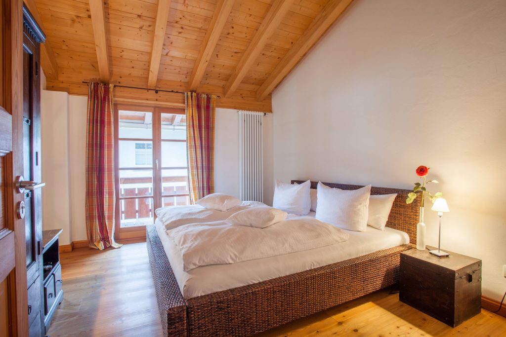 Doppelbett mit Gardienen in Ferienwohnung in Garmisch-Partenkirchen